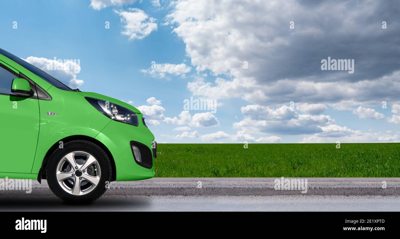 Voiture verte sur fond bleu ciel et champ. Copier l'espace Banque D'Images