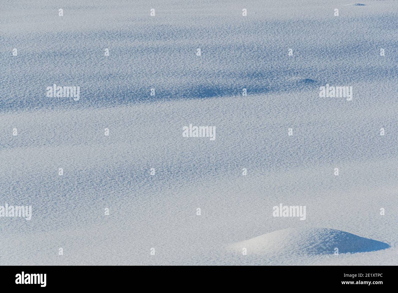 Neige douce s'écoule par temps ensoleillé. Des chutes de neige profondes et profondes sont illuminées par la lumière du soleil et par l'ombre Banque D'Images