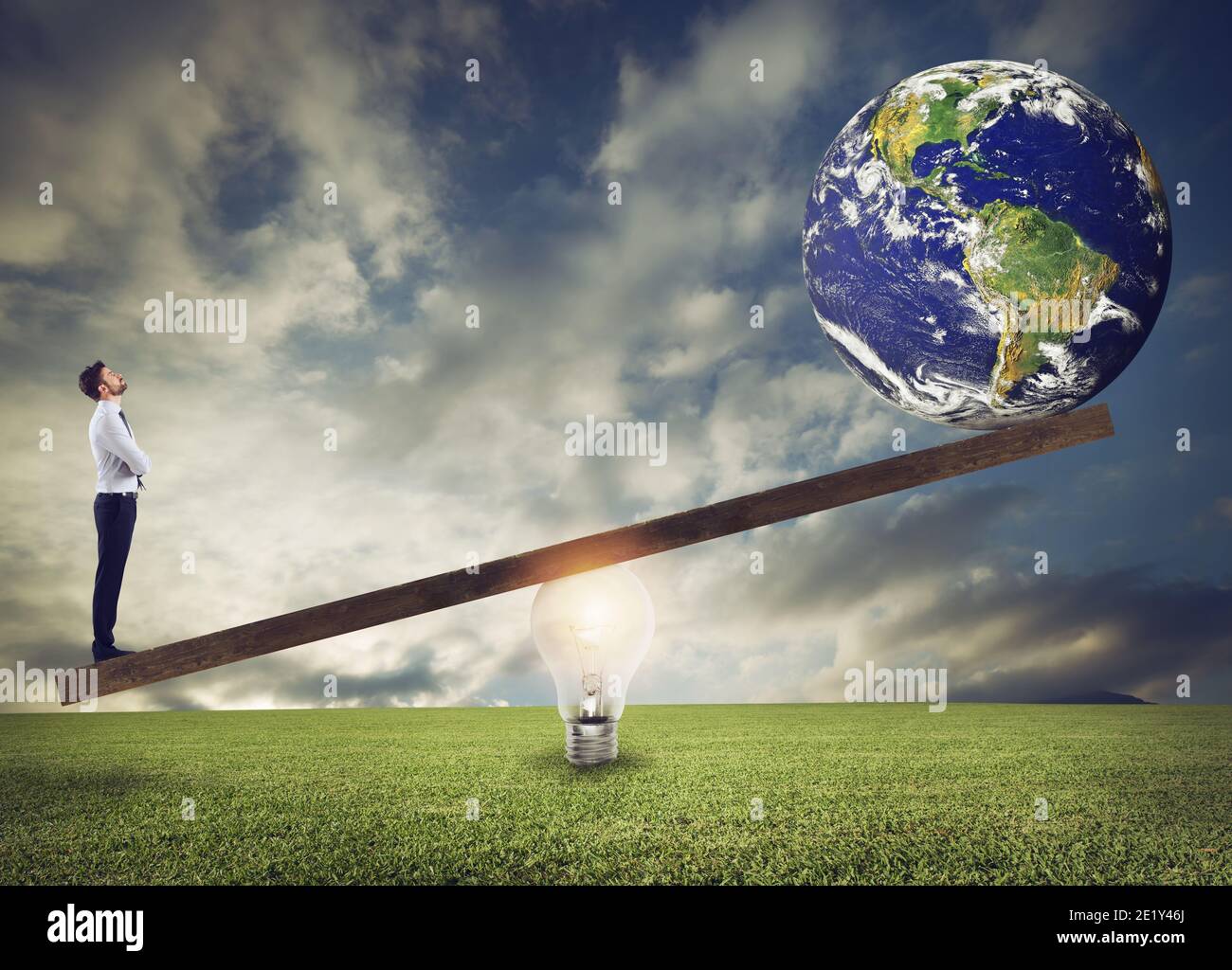 Homme d'affaires utilise un levier publicitaire d'ampoule pour soulever le monde. Terre fournie par la NASA. Banque D'Images
