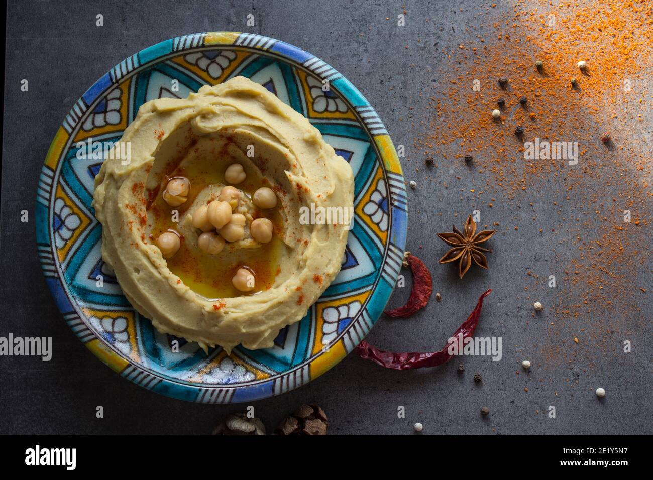 Photo vue de dessus de l'assiette de houmous. Nourriture du Moyen-Orient. Concept de saine alimentation. Arrière-plan gris avec espace de copie. Banque D'Images