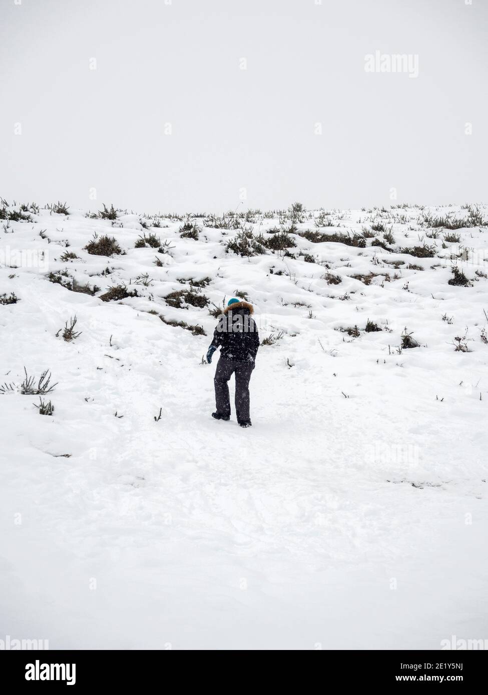 Homme marchant dans la neige sur la montagne Banque D'Images