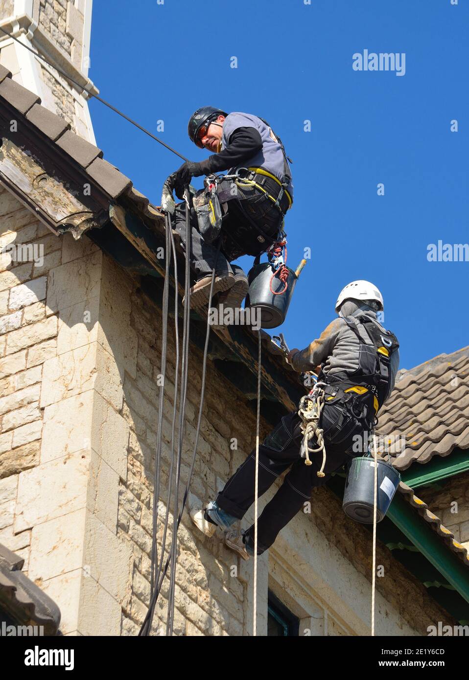 Descente en rappel des travailleurs de l'entretien des bâtiments au travail. Banque D'Images
