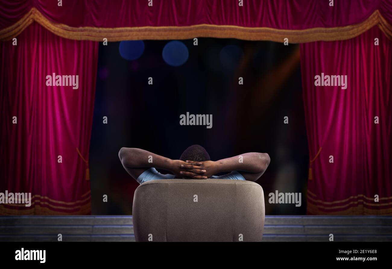 Homme se reposant sur un fauteuil et regarde un spectacle un théâtre Banque D'Images