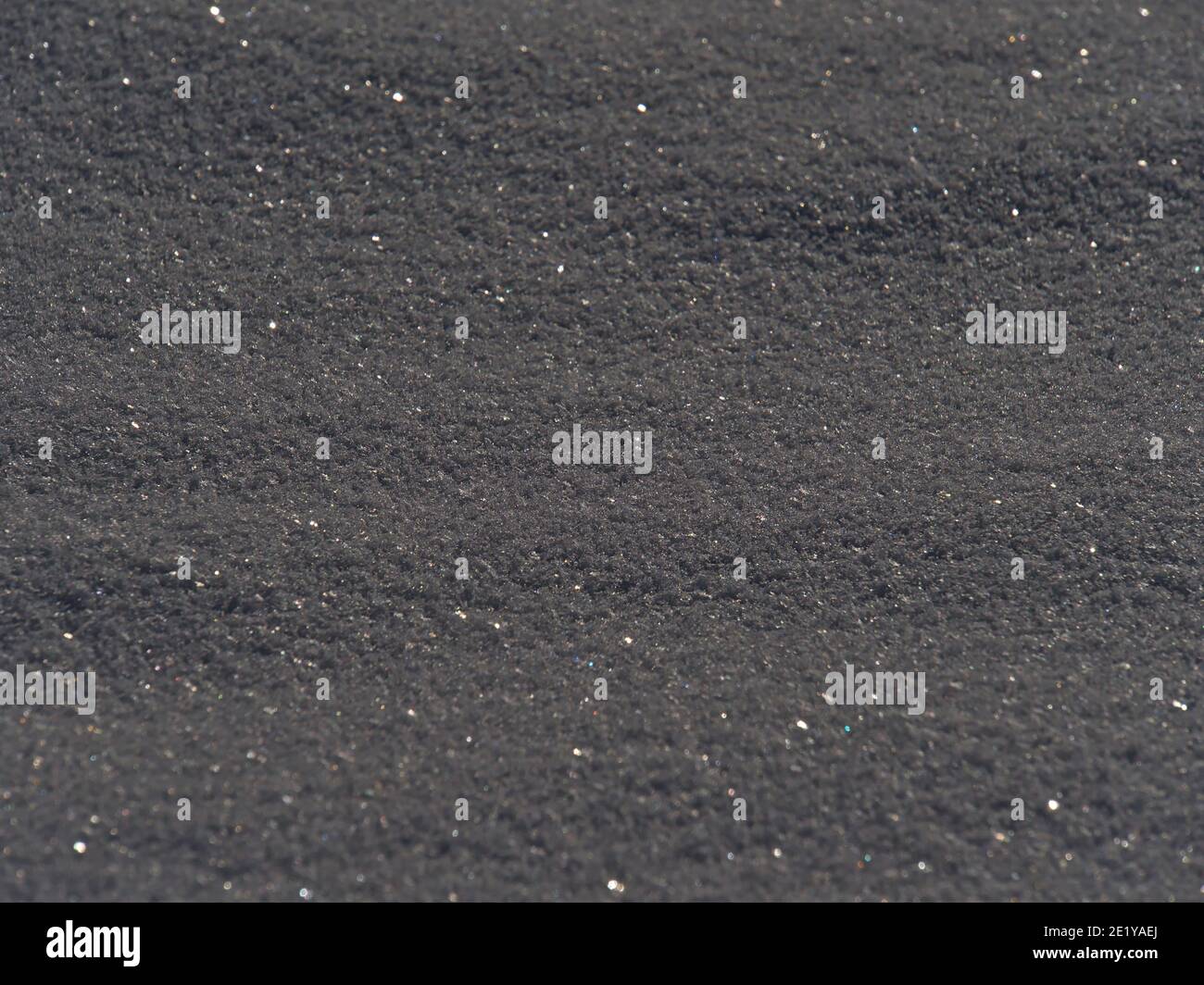 Gros plan avec une belle texture de champ couvert de neige en contre-jour avec des cristaux de glace scintillant au soleil en hiver. Banque D'Images