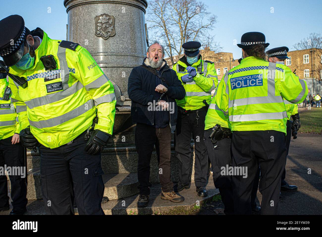 Un manifestant est arrêté et menotté par la police de Common lors de la manifestation anti-verrouillage le 9 janvier 2021 à Londres, en Angleterre Banque D'Images