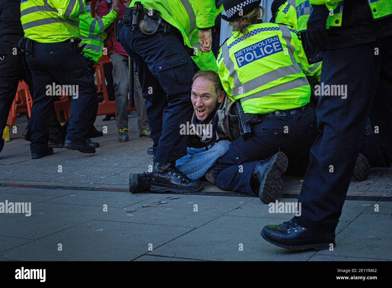 Un manifestant est arrêté par la police sur Clapham High Street lors de la manifestation anti-verrouillage le 9 janvier 2021 à Londres, en Angleterre Banque D'Images