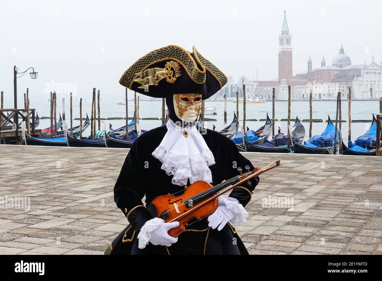 Homme vêtu d'un costume traditionnel décoré et d'un masque peint lors du Carnaval de Venise à Venise, en Italie Banque D'Images