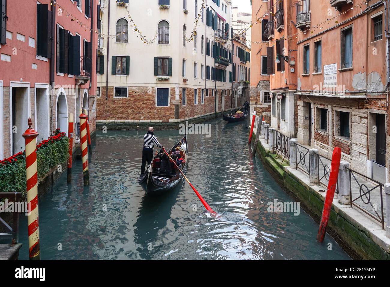 Gondole vénitienne traditionnelle avec des touristes sur le canal rio dei Bareteri à Venise, Italie Banque D'Images