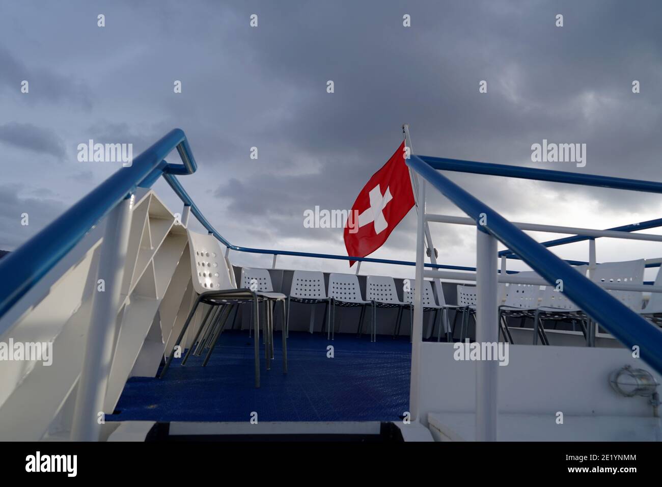 Drapeau fédéral suisse soufflant dans le vent au-dessus du lac de Zurich sur un bateau de croisière sur le lac. Banque D'Images