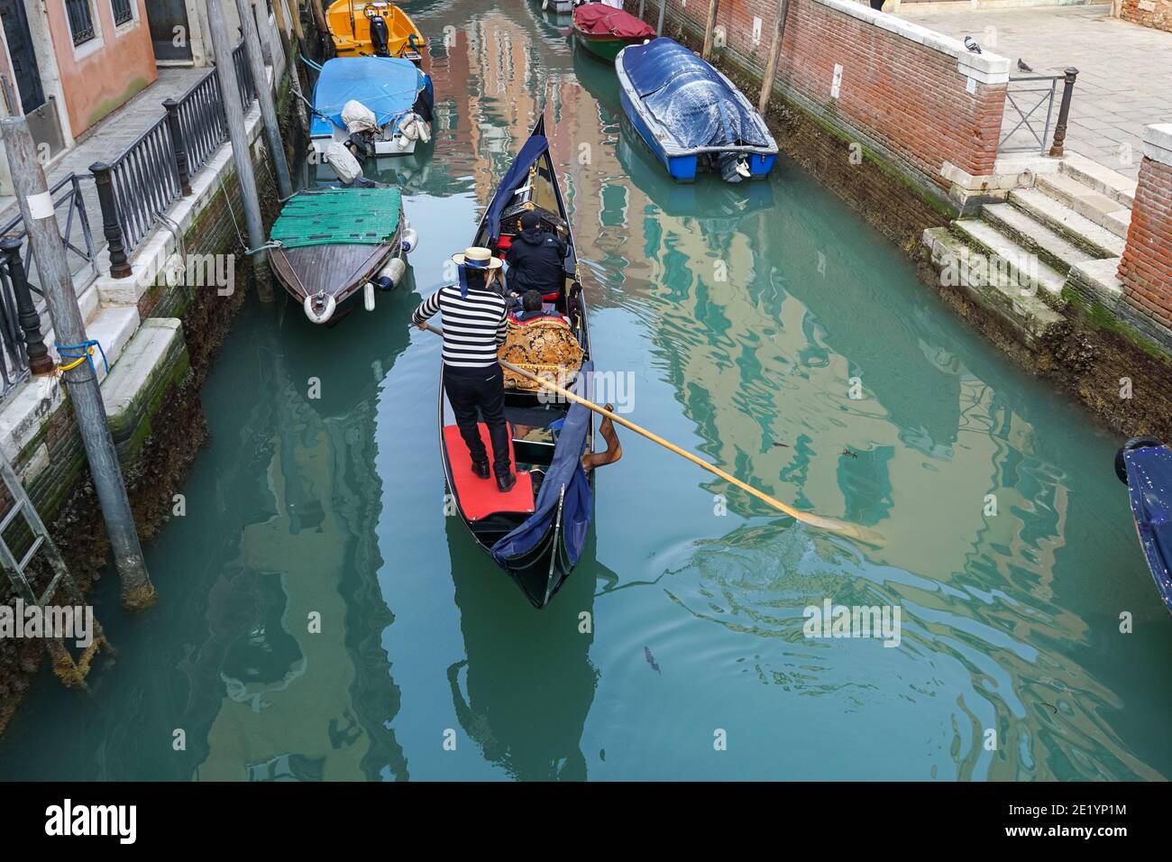 Gondolier sur une gondole vénitienne traditionnelle avec des touristes sur le canal à Venise, Italie Banque D'Images