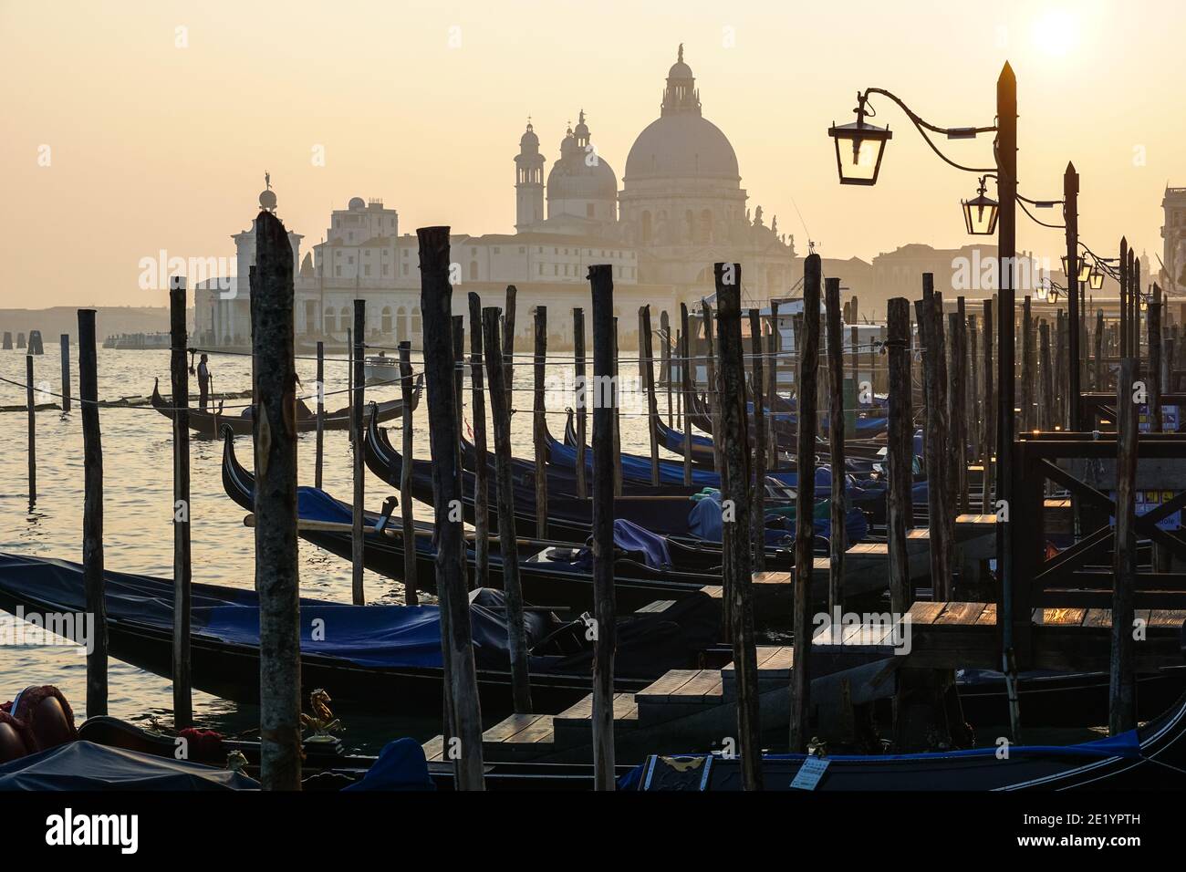 Gondole vénitienne au coucher du soleil, gondoles amarrées à Venise avec la basilique Santa Maria della Salute en arrière-plan, en Italie Banque D'Images