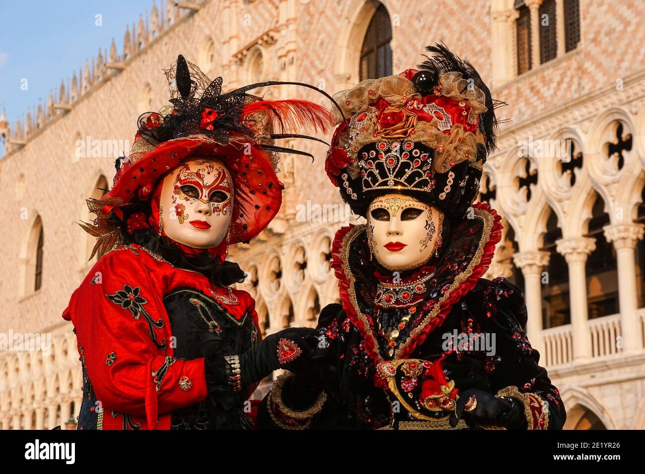 Deux femmes vêtues de déguisements et de masques traditionnels en face du Palais des Doges pendant le Carnaval de Venise à Venise, en Italie Banque D'Images