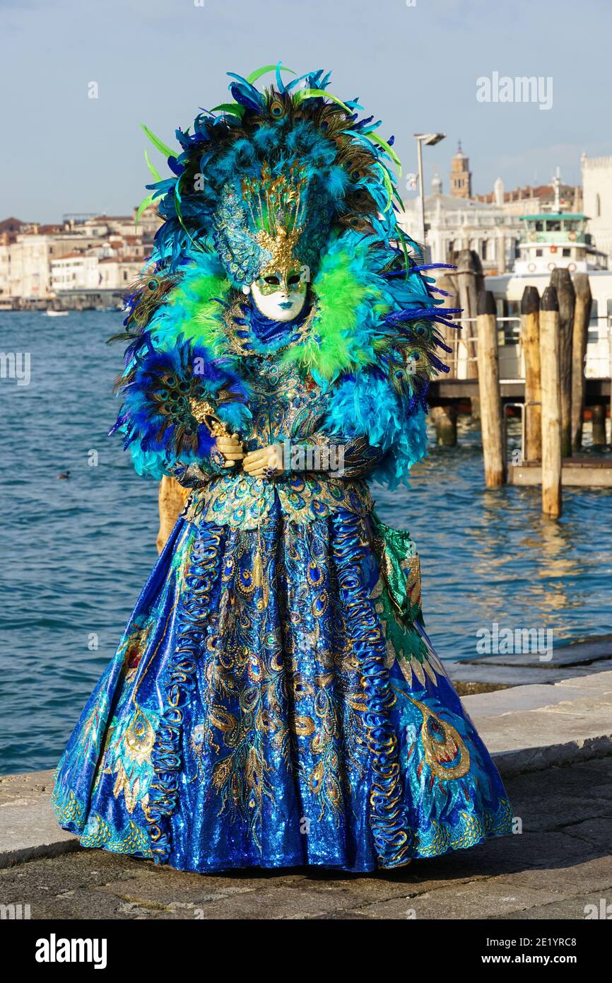 Femme habillée en costume traditionnel décoré avec des plumes et masque peint pendant le carnaval de Venise, Venise Italie Banque D'Images