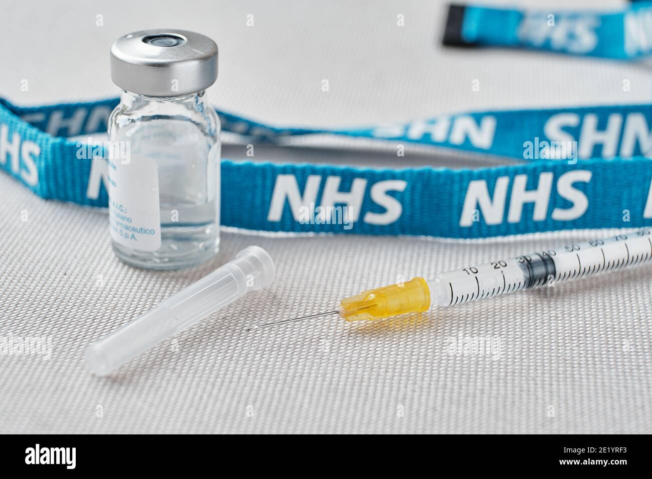 Stafford, Royaume-Uni - janvier 10 2021: Concept de vaccin NHS. Seringue, flacons d'injection et cordon NHS. Mise au point sélective. Banque D'Images