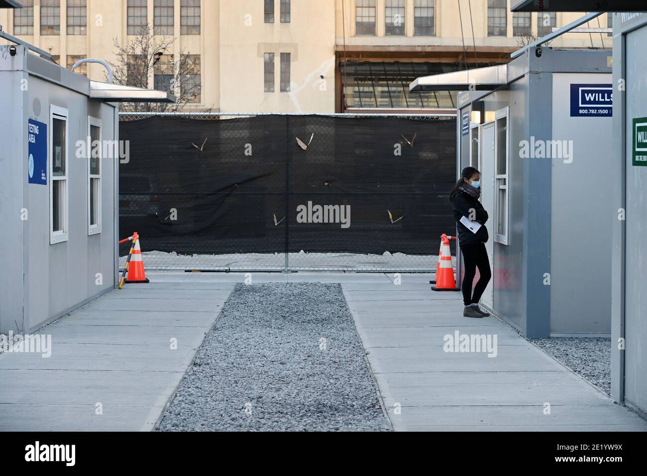 Une femme se tient à une fenêtre à l'intérieur du site de vaccination de l'hôpital NYCHealth situé à l'extérieur du terminal de l'armée de Brooklyn, dans le quartier de Brooklyn, New York, le 10 janvier 2021. Le 11 janvier, la ville de New York activera cinq points de vaccination prioritaires dans le groupe 1B, qui comprend les travailleurs de la santé, les travailleurs de l'éducation, les premiers intervenants, les travailleurs de la sécurité publique, les travailleurs des transports en commun et les quelque 1.4 millions de personnes âgées de 75 ans et plus. Le site DE LA CHAUVE-SOURIS sera équipé de 27 membres du personnel de vaccination dans le but de donner chacun 5 doses de vaccin COVID-19 par heure. (Photo par un Banque D'Images