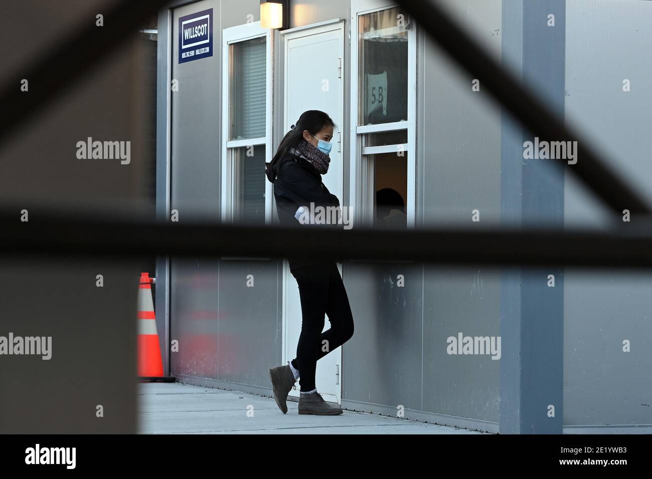 Une femme se tient à une fenêtre à l'intérieur du site de vaccination de l'hôpital NYCHealth situé à l'extérieur du terminal de l'armée de Brooklyn, dans le quartier de Brooklyn, New York, le 10 janvier 2021. Le 11 janvier, la ville de New York activera cinq points de vaccination prioritaires dans le groupe 1B, qui comprend les travailleurs de la santé, les travailleurs de l'éducation, les premiers intervenants, les travailleurs de la sécurité publique, les travailleurs des transports en commun et les quelque 1.4 millions de personnes âgées de 75 ans et plus. Le site DE LA CHAUVE-SOURIS sera équipé de 27 membres du personnel de vaccination dans le but de donner chacun 5 doses de vaccin COVID-19 par heure. (Photo par un Banque D'Images