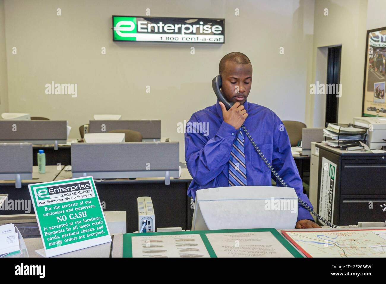 Alabama Montgomery Enterprise location de voitures, Black man réservationniste à la réception employé téléphone au comptoir, Banque D'Images
