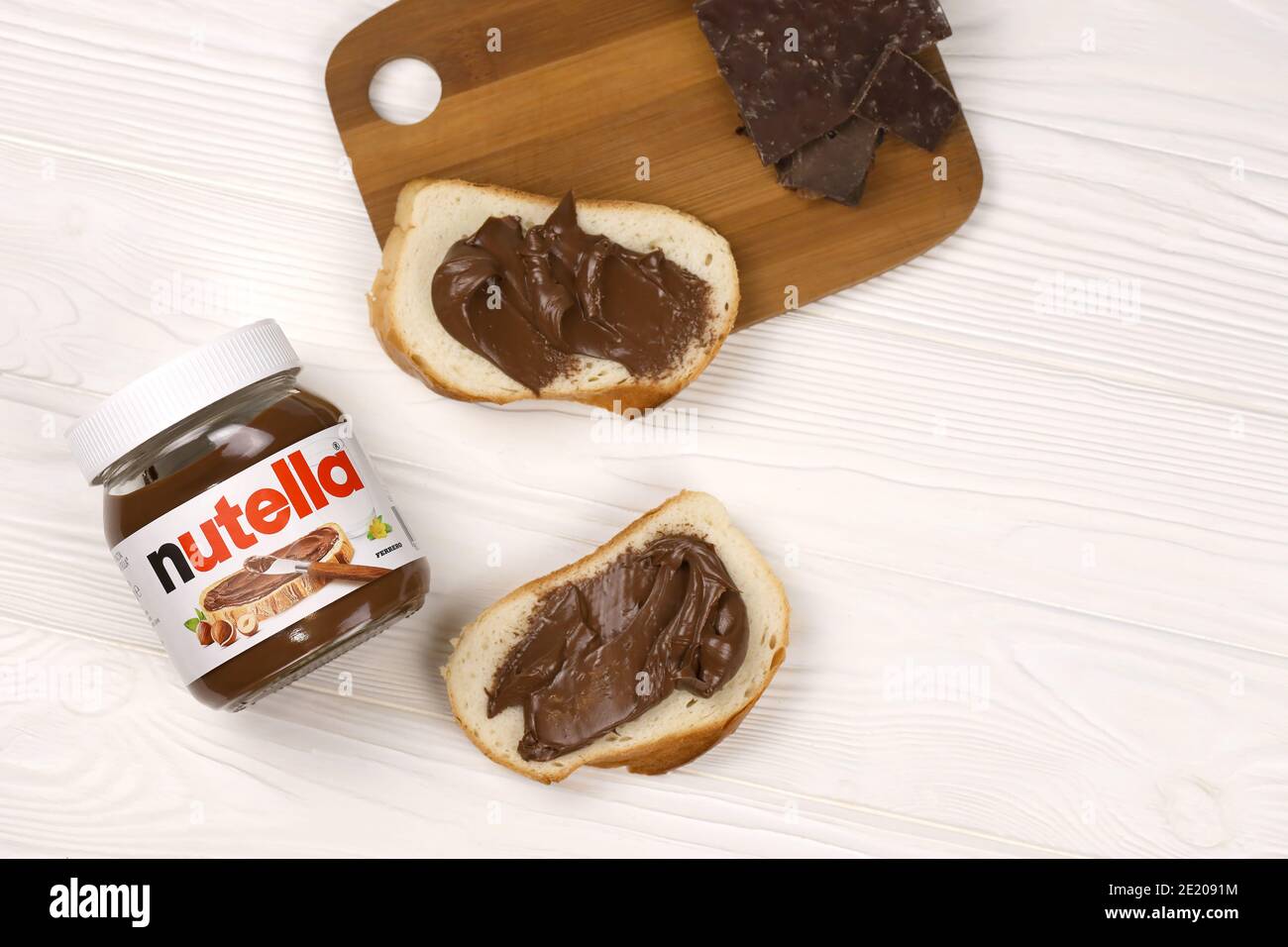 KHARKOV, UKRAINE - 27 DÉCEMBRE 2020 : le verre de Nutella peut et tartiner sur du pain frais. Nutella est fabriqué par la société italienne Ferrero firs Banque D'Images