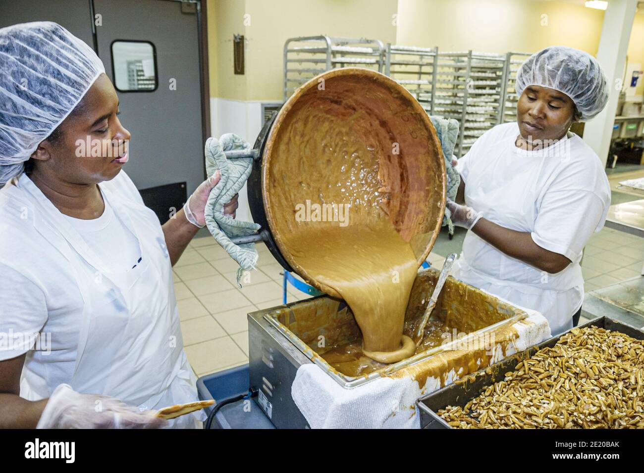 Alabama fort Deposit Priester's pecans Candy Maker, Black Woman femme travailleuse de production employé de travail verse revêtement pâte, Banque D'Images