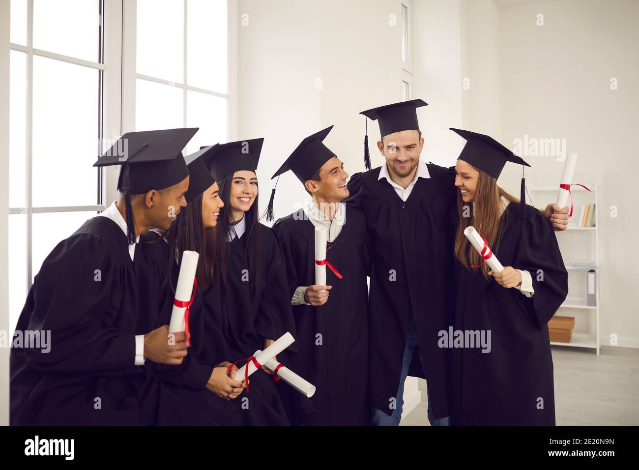 Groupe d'étudiants universitaires internationaux heureux avec des diplômes célébrant la remise des diplômes Banque D'Images