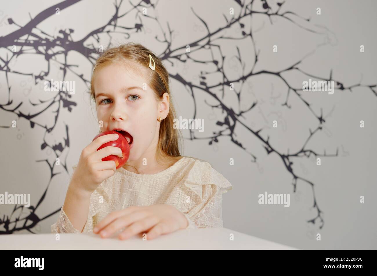 Fille blanche (enfant, enfant) mangeant une pomme rouge. Copier le texte d'espace Banque D'Images