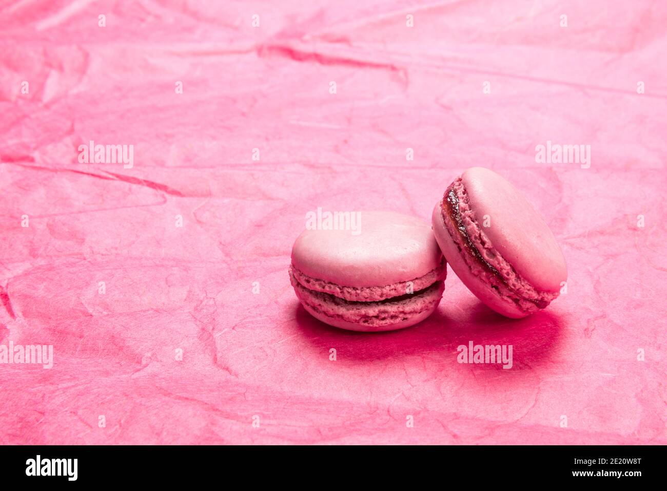Pâte de macarons français à la framboise sur fond de papier rose Banque D'Images