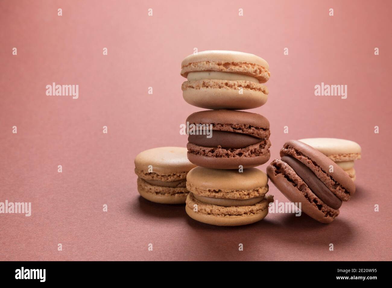 Pâte de macarons français aux saveurs de vanille, de café et de chocolat sur fond marron Banque D'Images