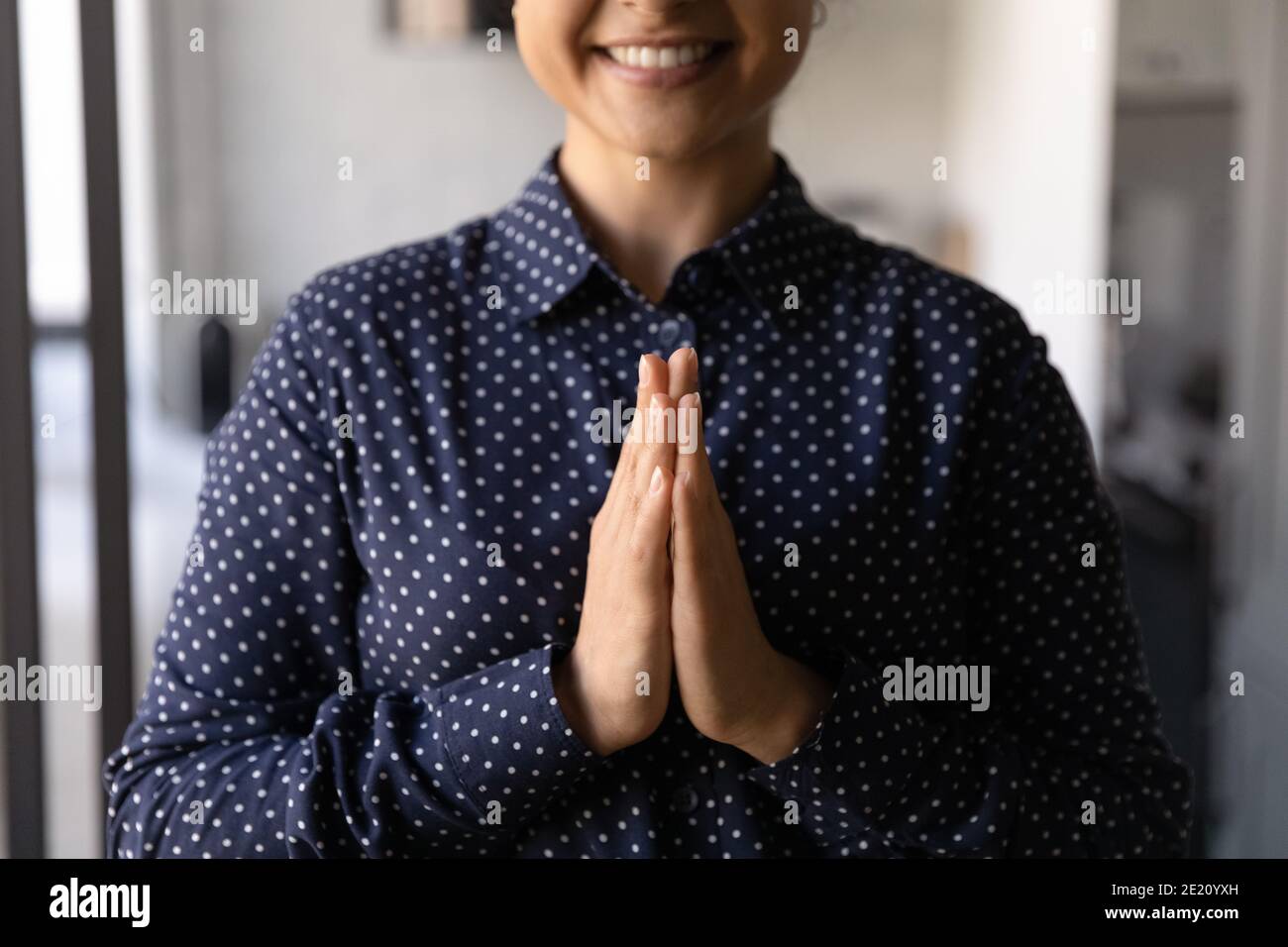 Gros plan de la femme souriante priez avec les mains dans la prière Banque D'Images