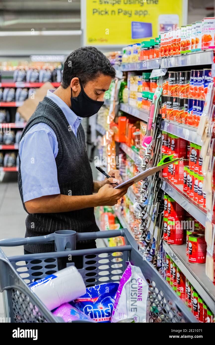 Cape Town, Afrique du Sud - 10 décembre 2020 : membre du personnel qui cueille les produits d'épicerie de l'étagère pour un service de livraison express à domicile au service local Pick n Pay su Banque D'Images