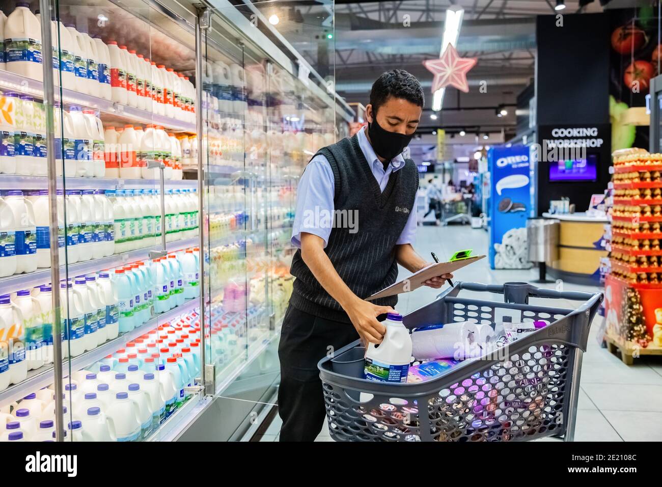 Cape Town, Afrique du Sud - 10 décembre 2020 : membre du personnel qui cueille les produits d'épicerie de l'étagère pour un service de livraison express à domicile au service local Pick n Pay su Banque D'Images