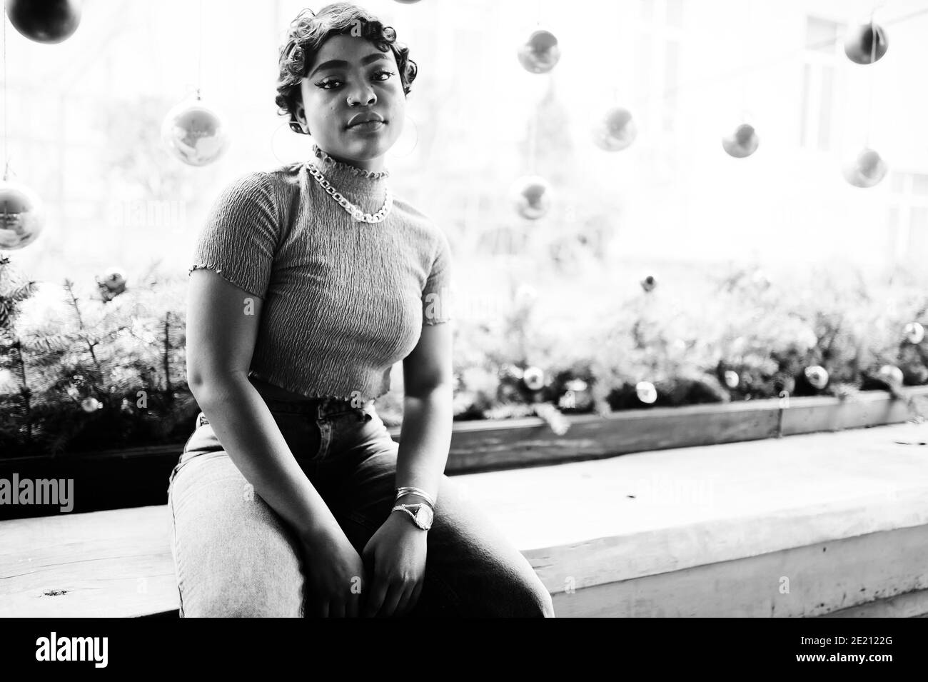 Jeune femme afro-américaine urbaine en haut rose et jeans gris. Afro mode chic femmes. Banque D'Images