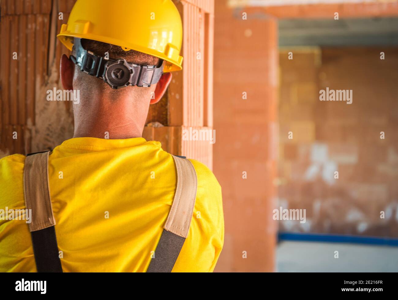 Travailleur caucasien portant un casque de sécurité à tête jaune. Zone du chantier de construction de casque dur. Sécurité sur le site. Banque D'Images