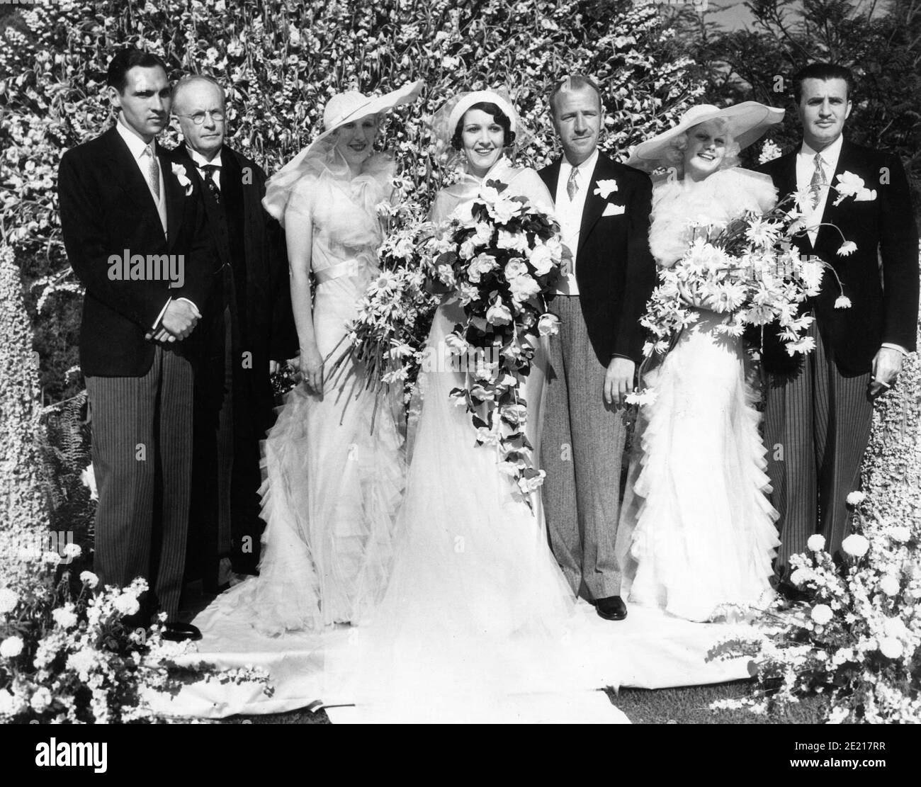Mariage du scénariste CAREY WILSON et de l'actrice CARMELITA GERAGHTY avec De gauche MAURICE GERAGHTY (frère de la mariée) LE RÉVÉREND JAMES HAMILTON LASH SHEILA GERAGHTY (Sœur de la mariée et aide d'honneur) La mariée et le marié JEAN HARLOW (Matron d'honneur) Et CÉDRIC GIBBONS (meilleur homme) Le 6 mai 1934 au domicile de l'agent de Bel-Air Phil Berg et sa femme Leila Hyams à Los Angeles Banque D'Images