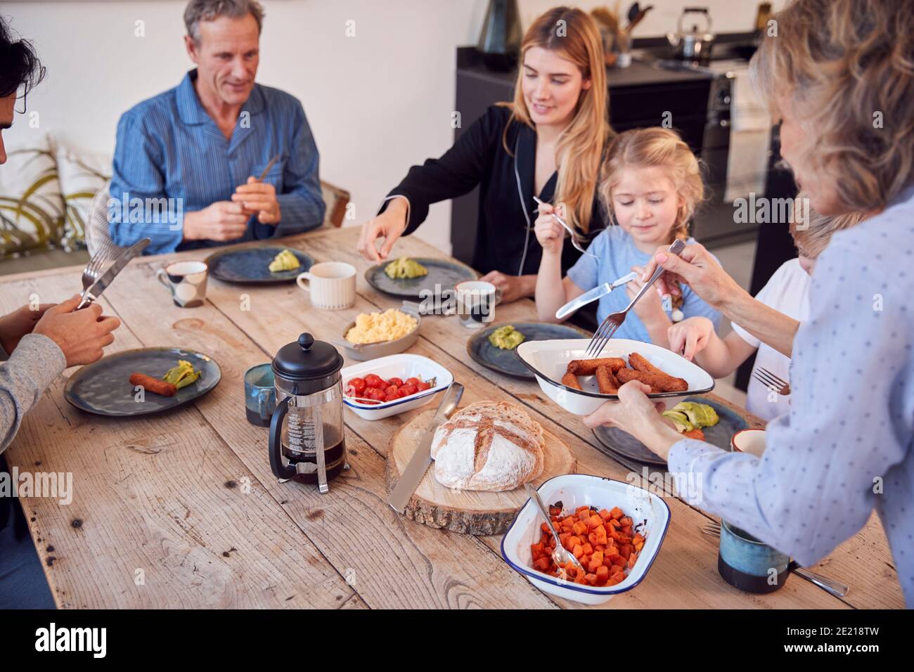 Famille de plusieurs générations assis autour de la table à la maison dans un pyjama Brunch ensemble Banque D'Images