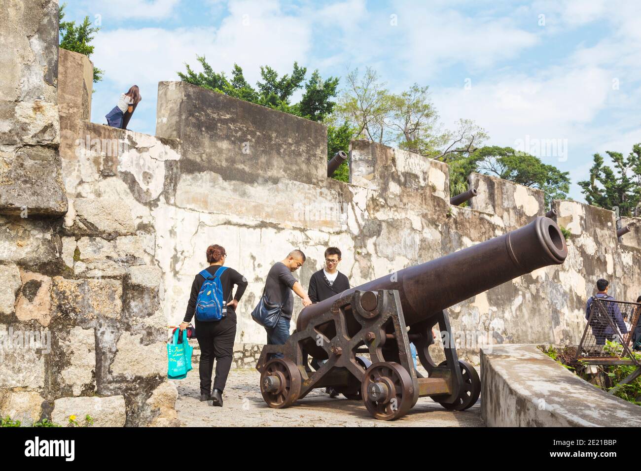 Macao, Chine. Visiteurs étudiant un canon par les murs de la construction portugaise Fortaleza do Monte. Le centre historique de Macao est un Heri mondial de l'UNESCO Banque D'Images