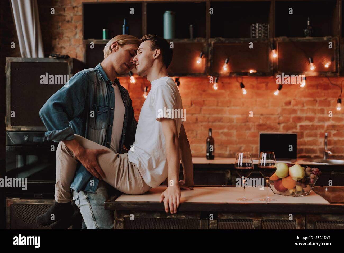 Couple gay aimant à la maison. Deux beaux hommes passionnés embrassant et embrassant en cuisine. Concept LGBT. Banque D'Images