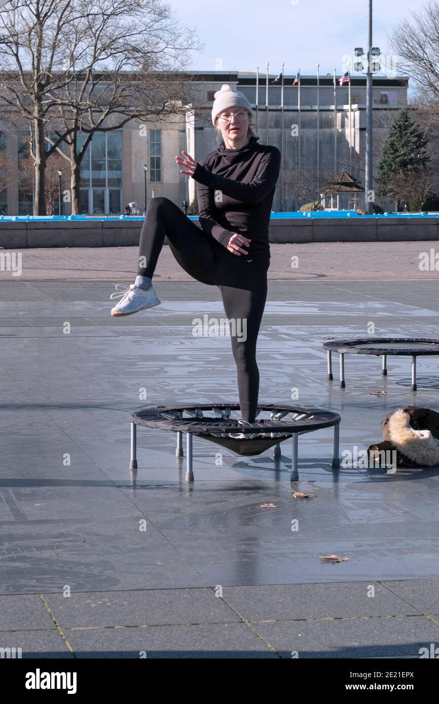 Une femme à une classe de rebondissement qui combine des mouvements vigoureux tout en sautant sur un petit trampoline. Dans le parc Corona de Flushing Meadows à Queens, New York. Banque D'Images
