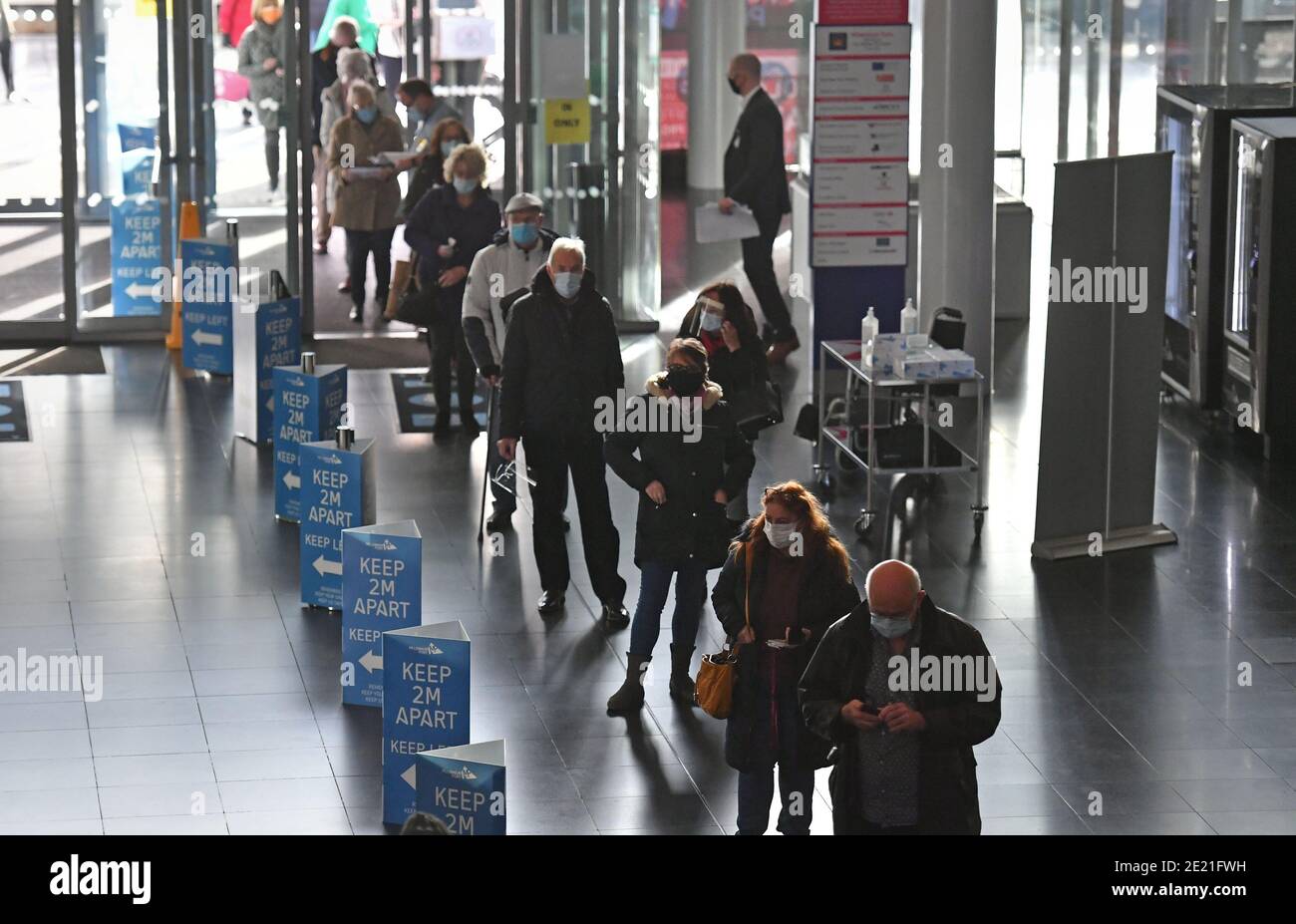 Les gens qui font la queue pour recevoir une injection d'un vaccin Covid-19 au centre de vaccination NHS qui a été mis en place au centre Millennium point de Birmingham. Le centre est l'un des sept centres de vaccination de masse maintenant ouverts au grand public alors que le gouvernement continue d'accélérer le programme de vaccination contre Covid-19. Banque D'Images