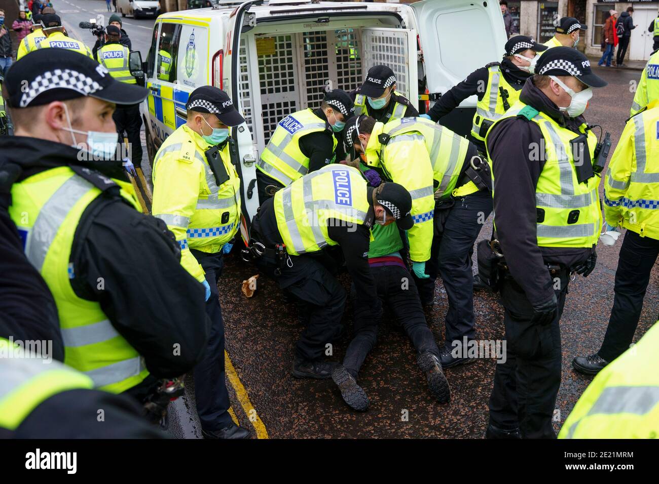 Édimbourg, Écosse, Royaume-Uni. 11 janvier 2021. Un manifestant a été arrêté aujourd'hui dans des scènes violentes lors d'une manifestation anti-verrouillage au Parlement écossais à Édimbourg. Plusieurs manifestants y ont participé, mais une présence policière lourde et agressive a empêché la manifestation et prévu une marche à Bute House. Au cours du confinement national de Covid-19, de telles manifestations sont illégales et la police a conseillé aux gens de ne pas assister à la manifestation. Pic; le manifestant féminin est arrêté et intégré dans une camionnette de police. Iain Masterton/Alay Live News Banque D'Images