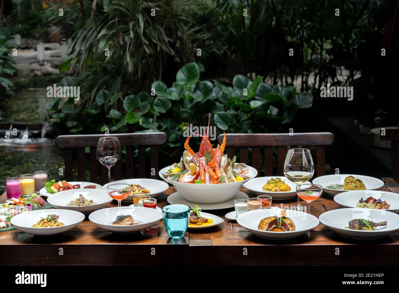 Vue latérale variété de spécialités internationales dans le jardin du restaurant de crevettes de homard steak boeuf agneau pâtes spaghetti risotto riz sushi sashimi a Banque D'Images