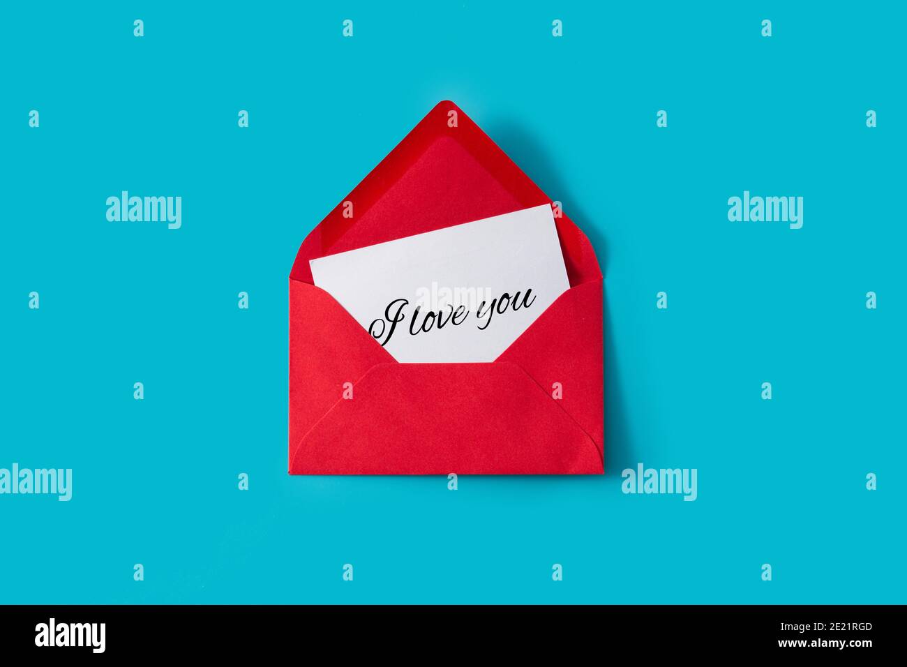 Remarque avec le message « Je t'aime » dans l'enveloppe rouge arrière-plan bleu Banque D'Images