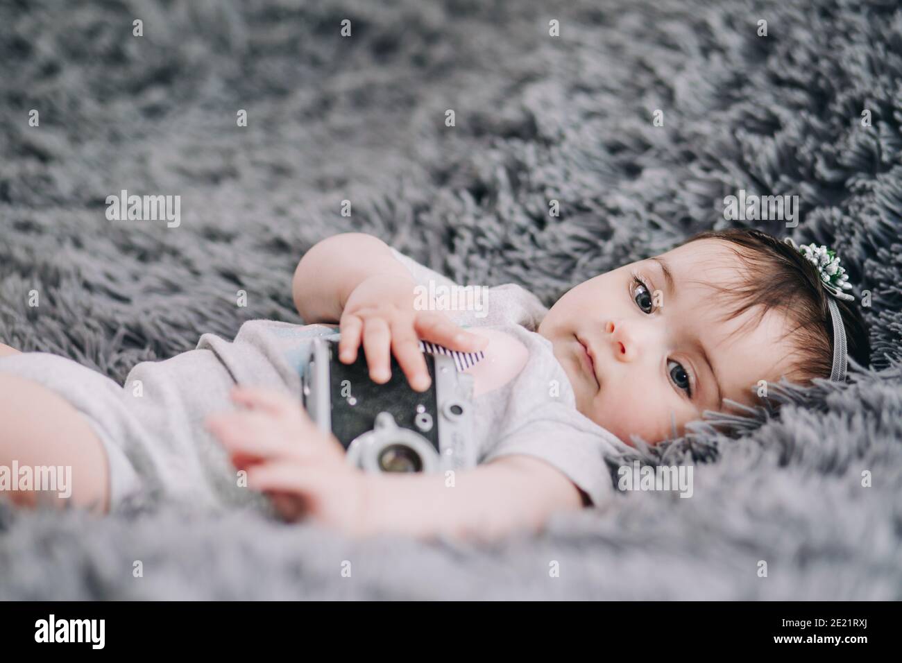 Gros plan de l'adorable et adorable bébé tenant un appareil photo reflex vintage Banque D'Images