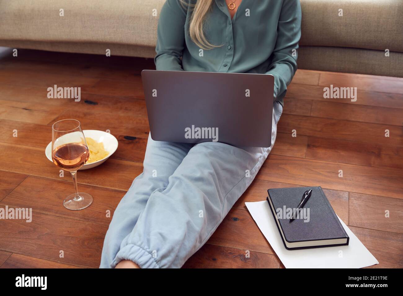 Gros plan sur Businesswoman à la fin de la journée avec vin Dans Loungewear et suit sur ordinateur portable travail à la maison Banque D'Images