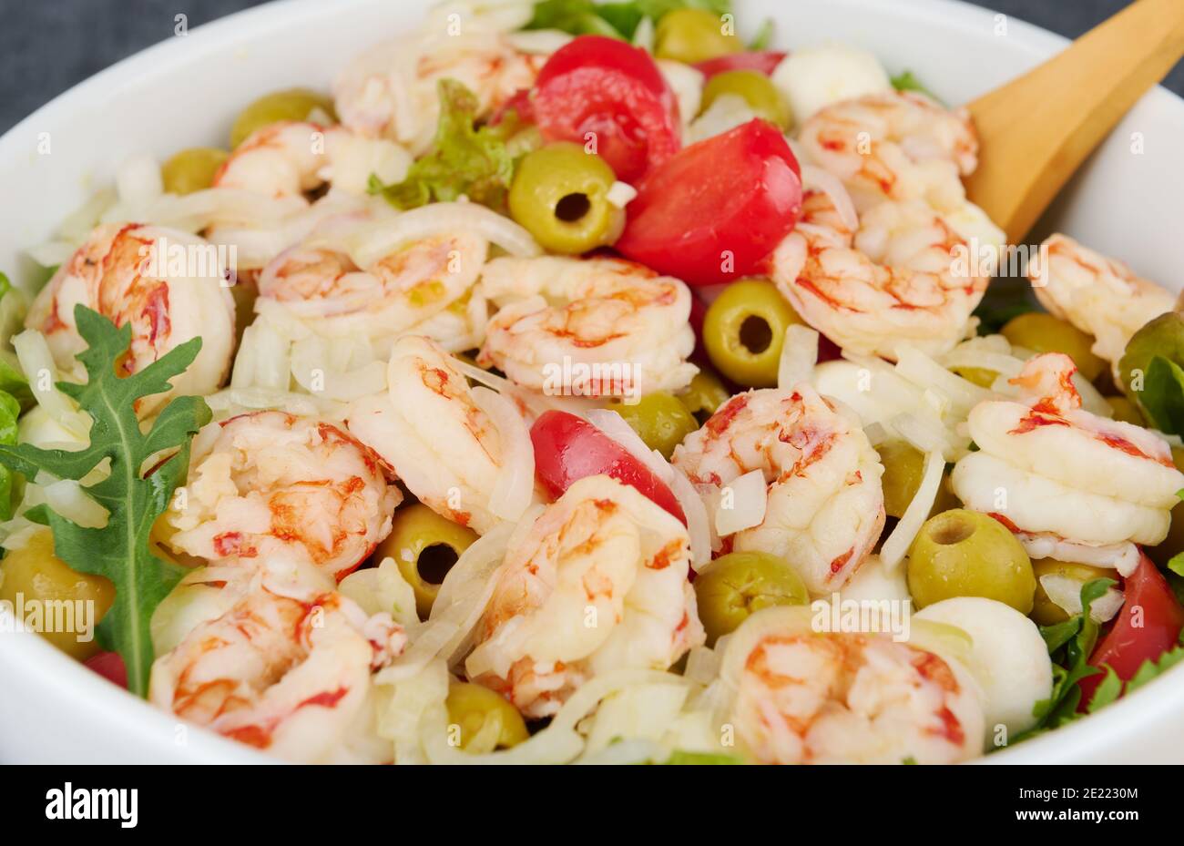 Salade délicieuse avec crevettes, olives, mozzarella, tomates et sauce à l'huile d'olive, gros plan, faible profondeur de la netteté Banque D'Images