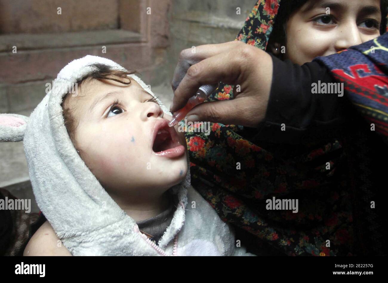 Un travailleur de la santé administre des gouttes de vaccin contre la polio à un enfant lors de la campagne de vaccination contre la polio, à Peshawar, le lundi 11 janvier 2021. Banque D'Images