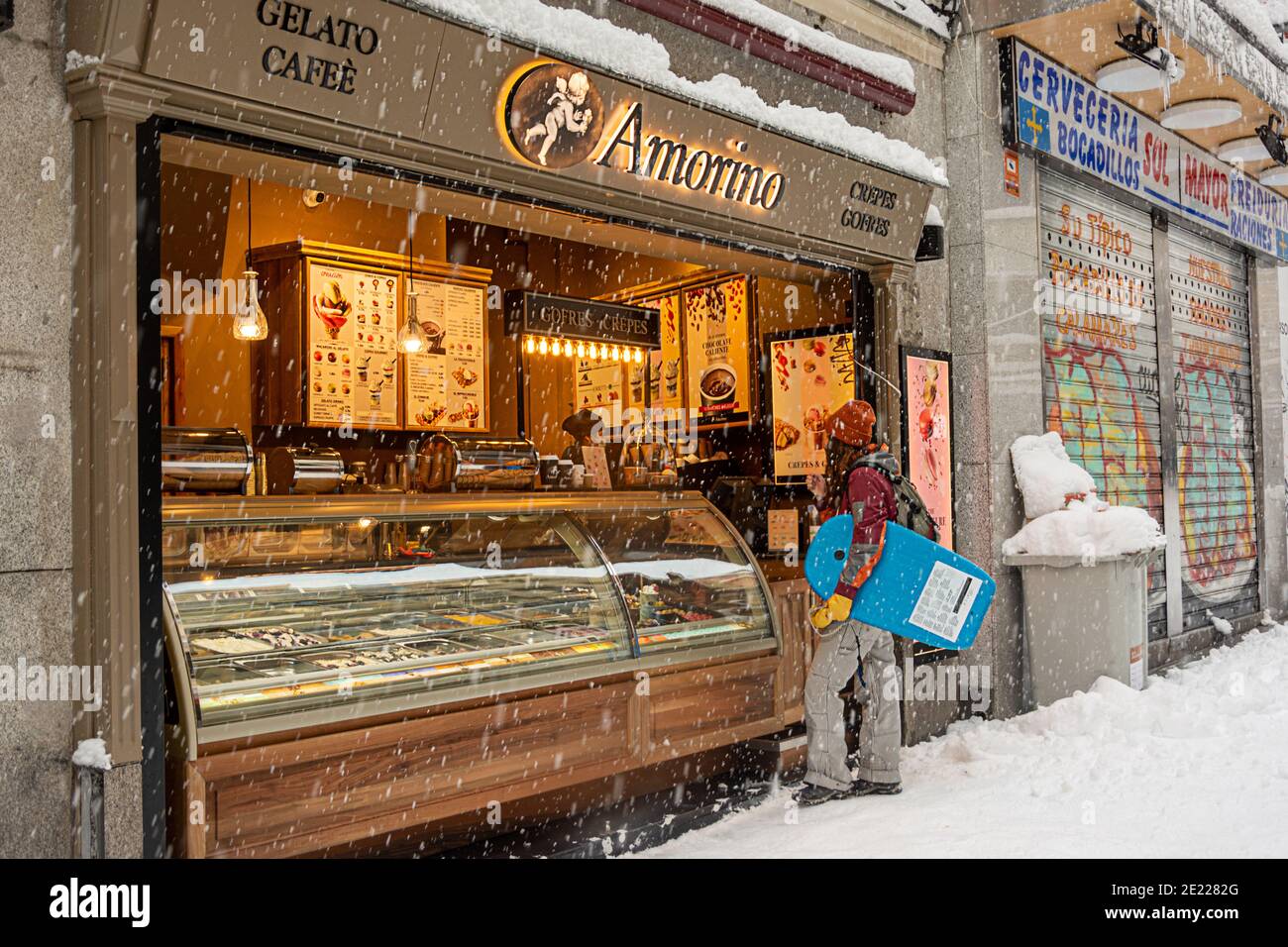 Madrid, Espagne, 01.09.2021, rue couverte de neige Postas, une jeune femme achetant un café dans le centre de Madrid, il neige, la tempête Filomena Banque D'Images