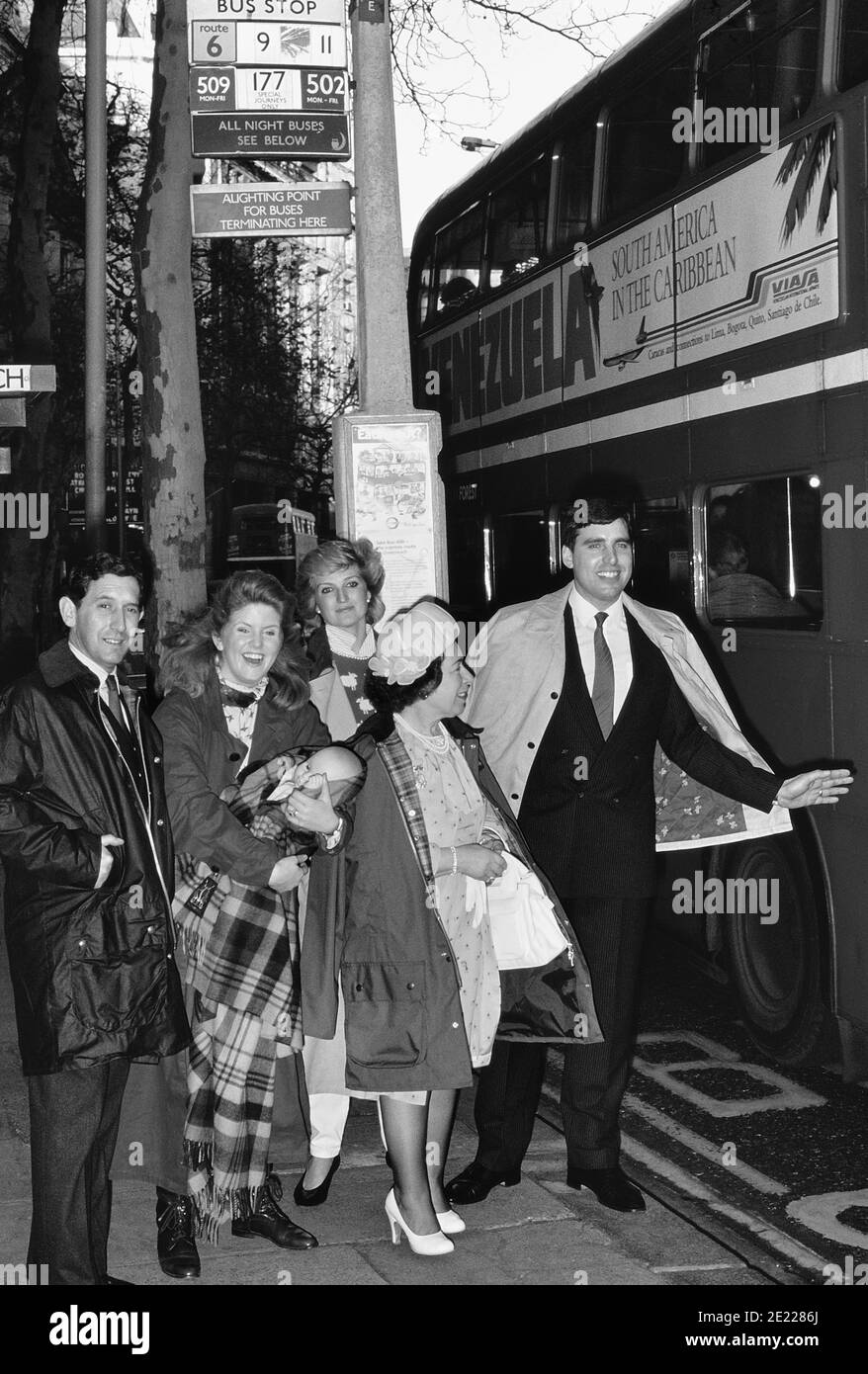 Un groupe d'usurpateurs de la famille royale britannique faisant la queue à un arrêt de bus pour prendre un bus rouge à impériale. Londres. Angleterre, Royaume-Uni, Circa 1989 Banque D'Images
