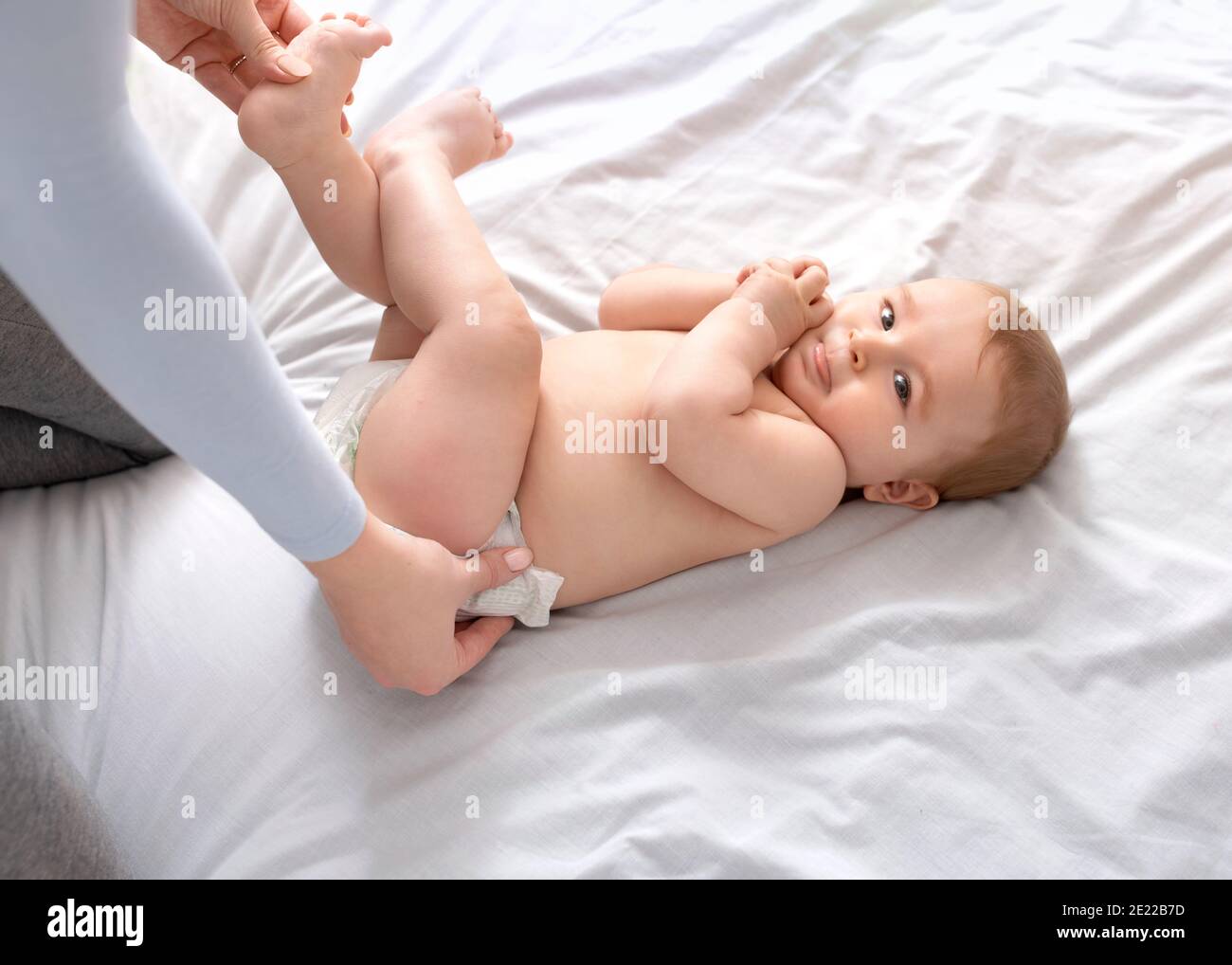 Bébé changeant de mère sur blanc, vue de dessus Banque D'Images