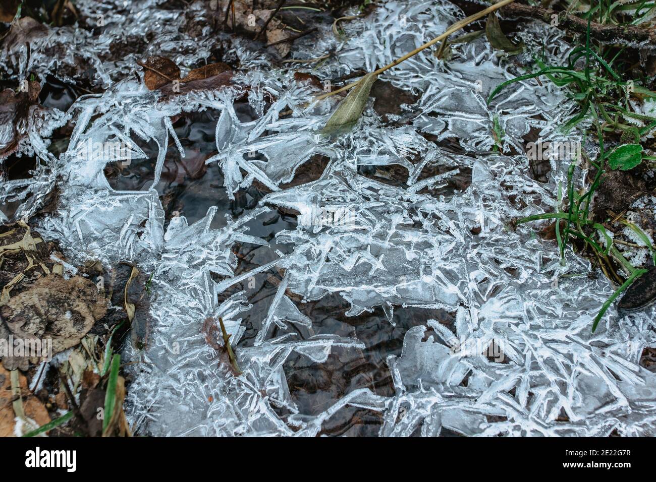 Arrière-plan d'hiver abstrait, glace craquelée sur le bas de la porte surgelé. Fragments de glace sur l'eau gelée. La glace morceaux brisés.glace sur une flaque d'eau gelée en hiver Banque D'Images