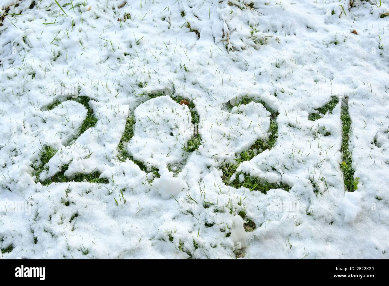 Numéro 2021 écrit dans la neige mince sur la pelouse, de sorte que l'herbe devient visible, nouveau concept d'année ou carte de voeux, sélection de focus, profondeur étroite de fie Banque D'Images